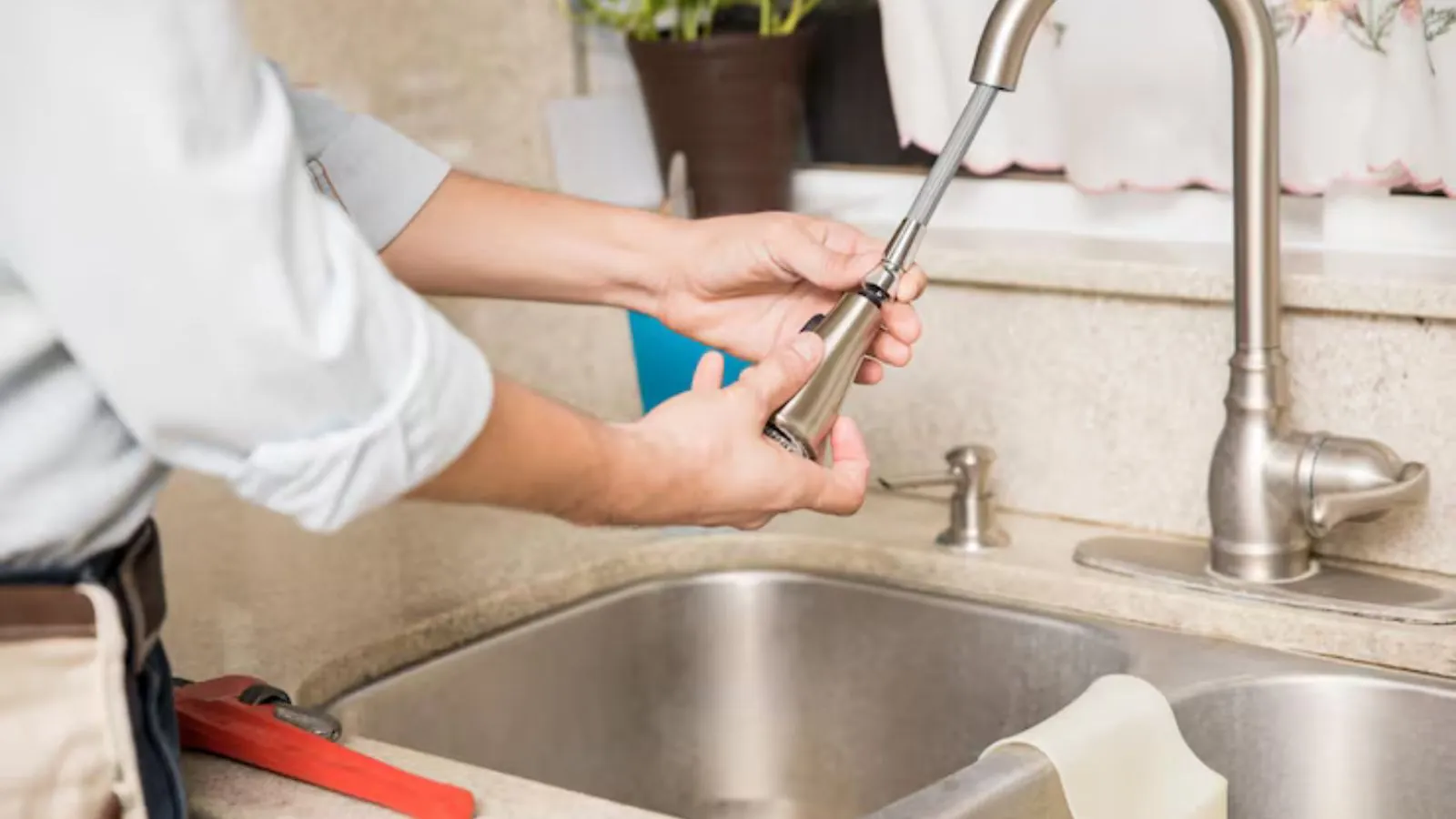 Plumber repairing a kitchen faucet