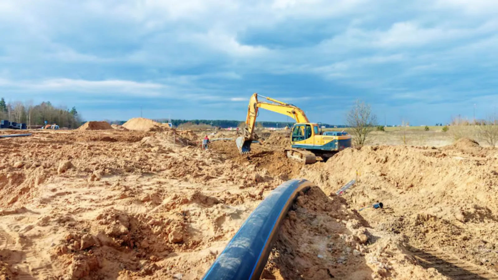 Excavator digging a trench for sewer line replacement